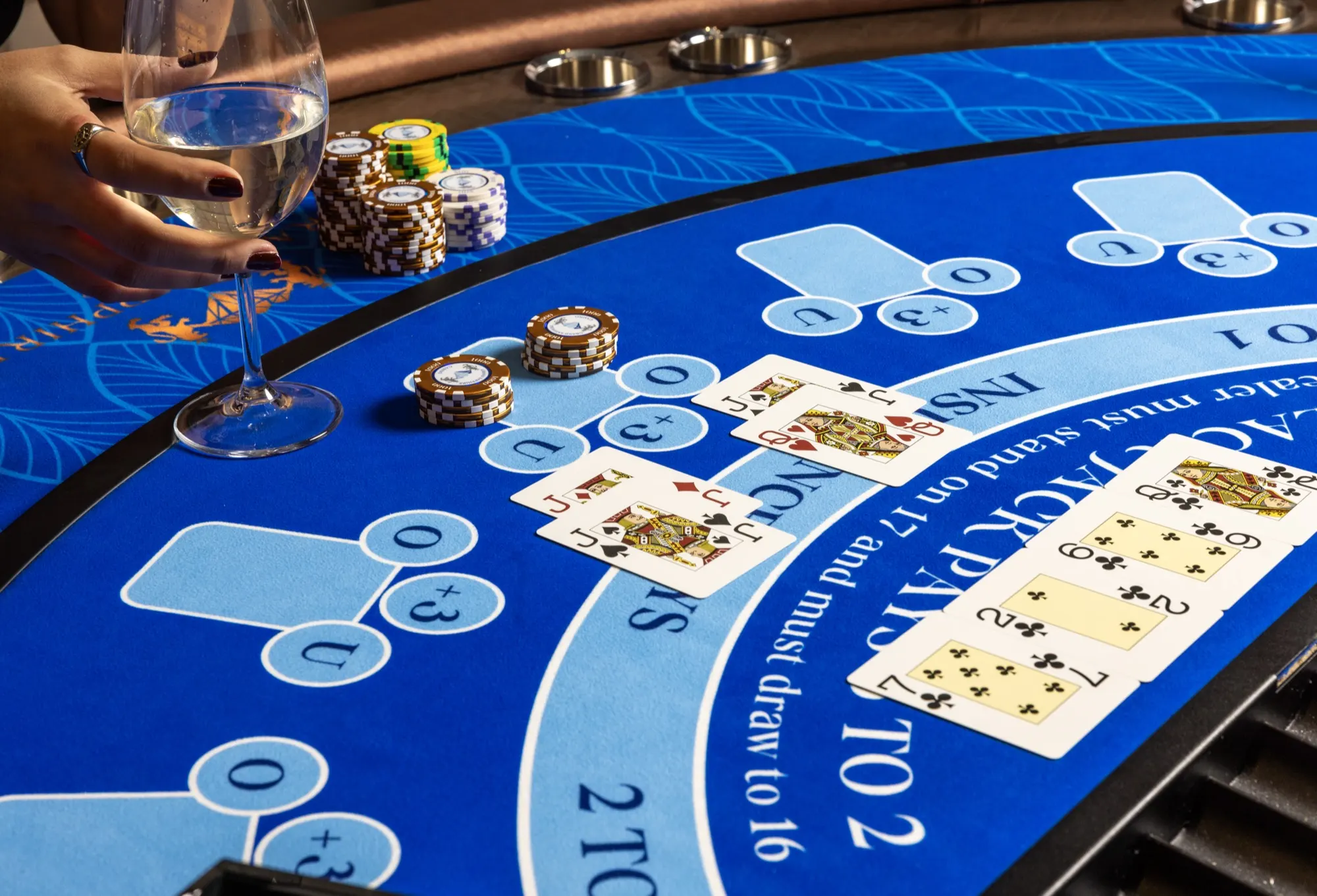 Blackjack table with chips and a wine glass